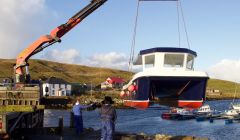 The new catamaran is slowly lifted into the water at the Vidlin marina on Thursday. Photos: Hans J Marter/Shetland News