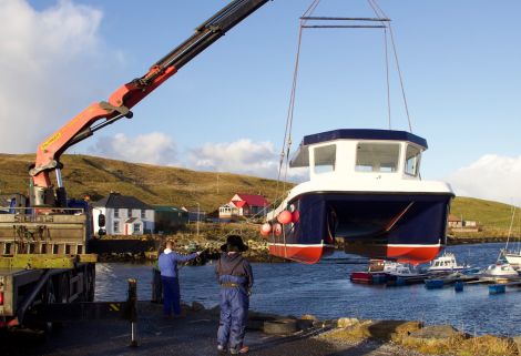 The new catamaran is slowly lifted into the water at the Vidlin marina on Thursday. Photos: Hans J Marter/Shetland News