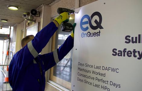 All change at SVT: a DITT worker replaces a BP safety sign with EnQuest's own branding.