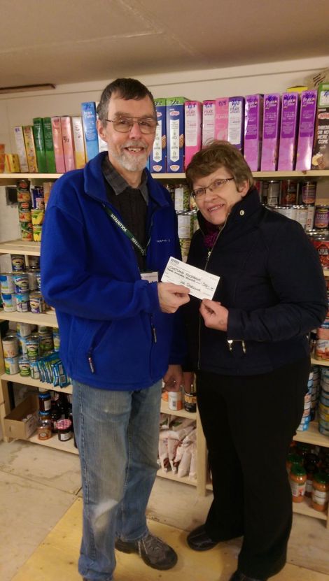 Andrea Manson of Wir Shetland presenting a cheque to David Grieve of the Shetland Foodbank.