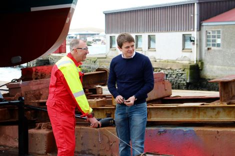 Malakoff's Ryan Stevenson (right) preparing the champagne bottle before it was smashed against the boat.