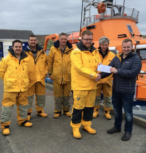 Captain Marius Joensen presenting the cheque to crew member John Robertson. Also pictured, left to right, are Allan Willmore, Chris Smith, David Nicolson and Luke Bullough. Missing from picture are Lewis Fraser and Pete Hanscombe. Photo: RNLI/Liz Boxwell