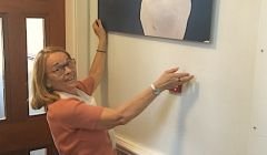 Georges Dif's widow Nelly hanging one of his photos at Islesburgh Community Centre last week. Photo: Jonathan Wills