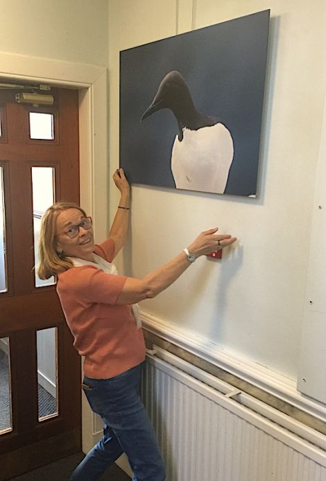 Georges Dif's widow Nelly hanging one of his photos at Islesburgh Community Centre last week. Photo: Jonathan Wills