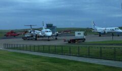 A group of planes parked on a tarmac.