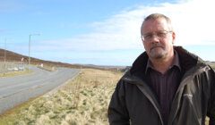 A man standing on the side of a road.