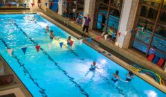 A group of people in an indoor swimming pool.