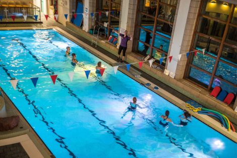 A group of people in an indoor swimming pool.