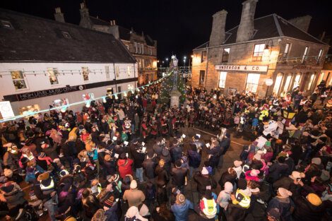 A crowd of people gathered on a street at night.