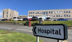 A hospital sign in front of a building.