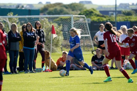 A group of women playing soccer on a field.