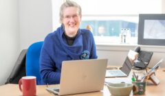 A woman sitting at a desk with a laptop in front of her.