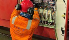 A technician in protective gear works on an open electrical control panel labeled "L.E.F. Lenrick Engineering & Fabrication Ltd.