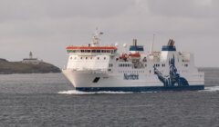 A large ferry named "NorthLink" sails in open water, with a lighthouse visible in the background. © Austin Taylor Photography, 2023.