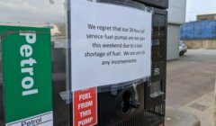 A sign on a fuel pump reads, "We regret that our 24 hour self service fuel pumps are not open this weekend due to a local shortage of fuel. We are sorry for any inconvenience.