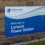 Sign reading "Welcome to Lerwick Power Station" with the logo of Scottish & Southern Electricity Networks against a brick wall background.