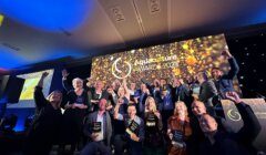 A group of people pose on stage holding awards at the Aquaculture Awards 2023 with a celebratory backdrop displaying the event name.