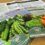 Packets of vegetable seeds, including peas, lettuce, and carrots, are arranged on a wooden surface. The packets display colorful images of the vegetables. Gardening information sheets are visible in the background.