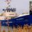 A blue and white boat named "Good Shepherd IV" is docked near a pier. Inset shows a close-up of a man wearing glasses.