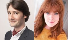 A man with brown hair in a suit and red scarf smirking on left; a woman with red hair in a mustard sweater smiling on right.