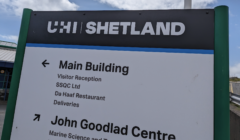 A sign for UHI Shetland directing to the Main Building and John Goodlad Centre with various facilities listed underneath each heading.