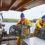 Two fishermen hauling nets on a boat.