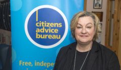 Woman standing in front of a citizens advice bureau banner.