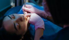 Dental examination in progress with a patient reclining as a dentist performs a check-up.