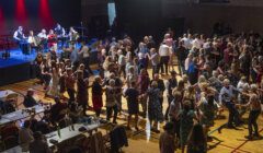 Crowd enjoying a dance with a live band performing on stage.