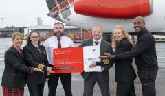 Airline staff holding an award sign in front of an aircraft, commemorating their recognition as "era airline of the year 2023.