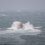 A lifeboat in rough sea conditions with waves crashing around it.