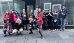 A group of people posing in front of a store.