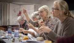 A group of women engaged in a knitting class, focusing intently on their craft.