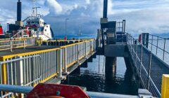 A ferry dock with a moored ship under cloudy skies.