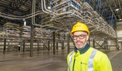 A man in a hard hat standing in a warehouse.