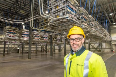 A man in a hard hat standing in a warehouse.