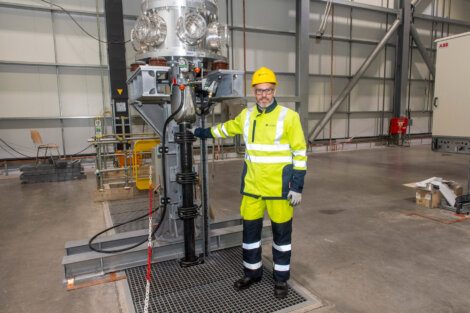 A man standing next to a machine in a warehouse.