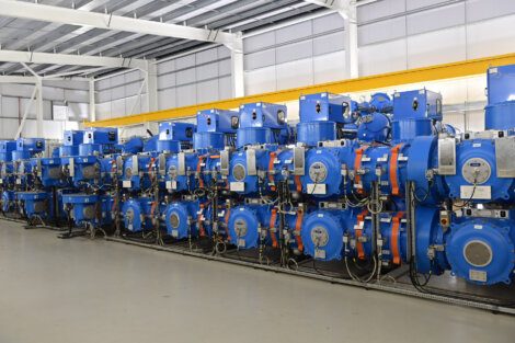 A line of blue valves in a warehouse.