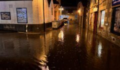 A city street is flooded at night.