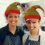 Two women wearing elf hats in a kitchen.