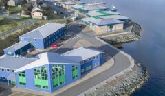 An aerial view of a blue building next to the water.