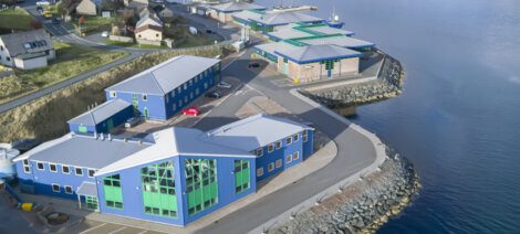 An aerial view of a blue building next to the water.