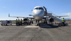 A white airplane is parked on the tarmac.