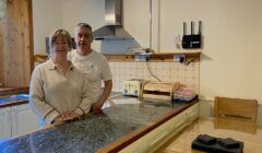 A man and woman standing in a kitchen.