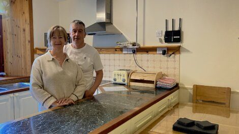 A man and woman standing in a kitchen.