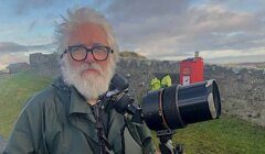 A man with a beard and glasses holding a camera.