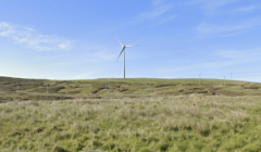 A windmill on a grassy hill.