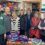 A group of people standing in front of shelves of food.