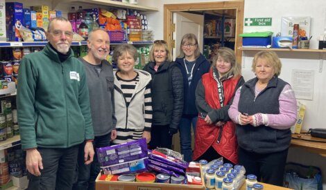 A group of people standing in front of shelves of food.