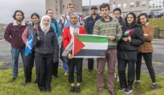 A group of people posing with a palestinian flag.